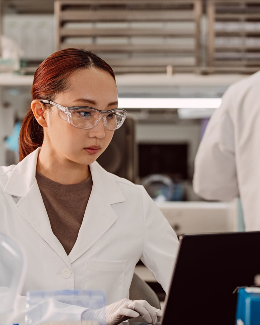 scientist in lab reviewing data on laptop